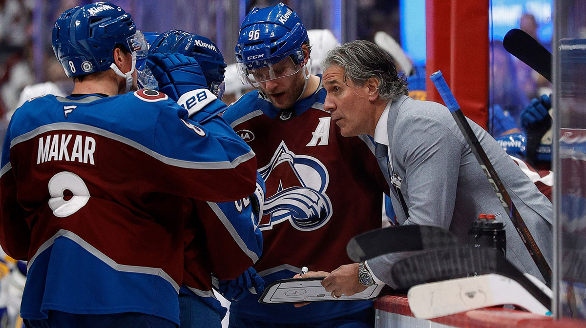 Colorado Avalanche head coach Jared Bednar talks with defenseman Cale Makar (8) and right wing Mikko Rantanen (96) during a timeout in the third period against the Buffalo Sabres at Ball Arena.