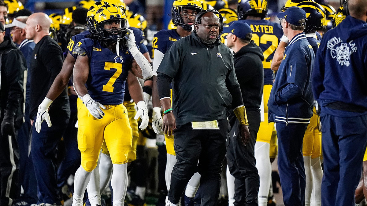 Michigan running back coach Tony Alford, right, and running back Donovan Edwards, left, walk along the sideline during the first half against Michigan State at Michigan Stadium