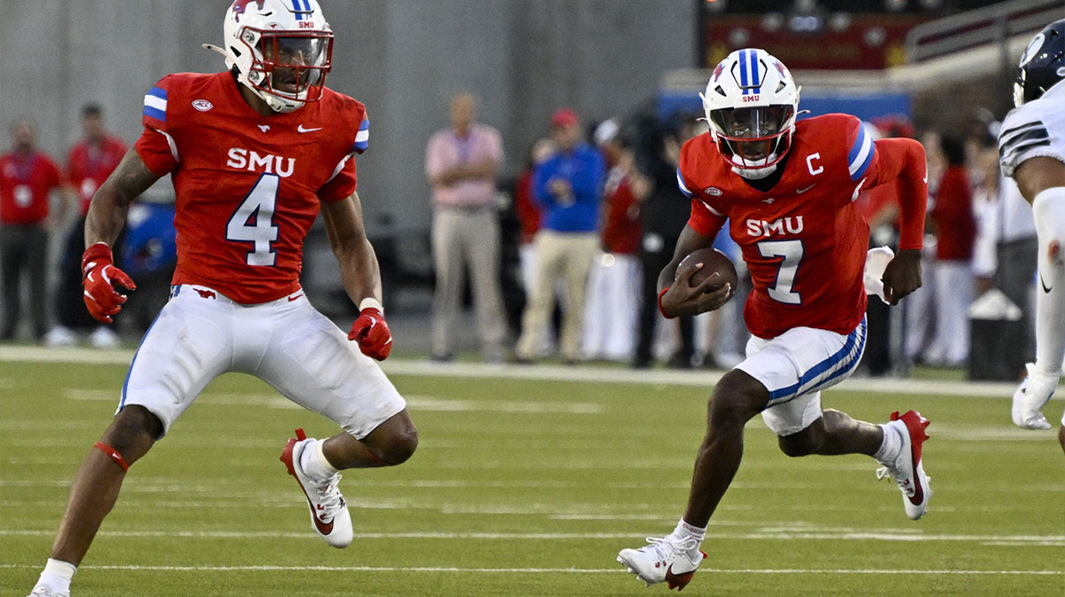 Southern Methodist Mustangs running back Jaylan Knighton (4) and quarterback Kevin Jennings (7) in action during the game between the Southern Methodist Mustangs and the Brigham Young Cougars at Gerald J. Ford Stadium.