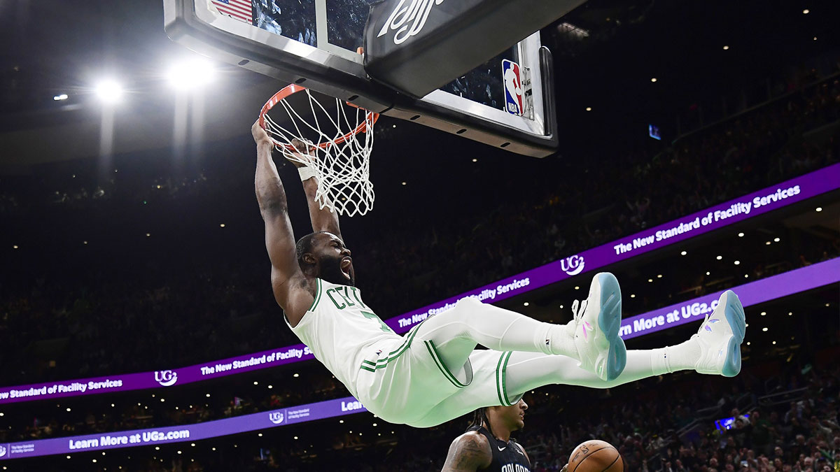 Boston Celtics guard Jaylen Brown (7) hangs on the rim after dunking the ball during the second half against the Orlando Magic at TD Garden.