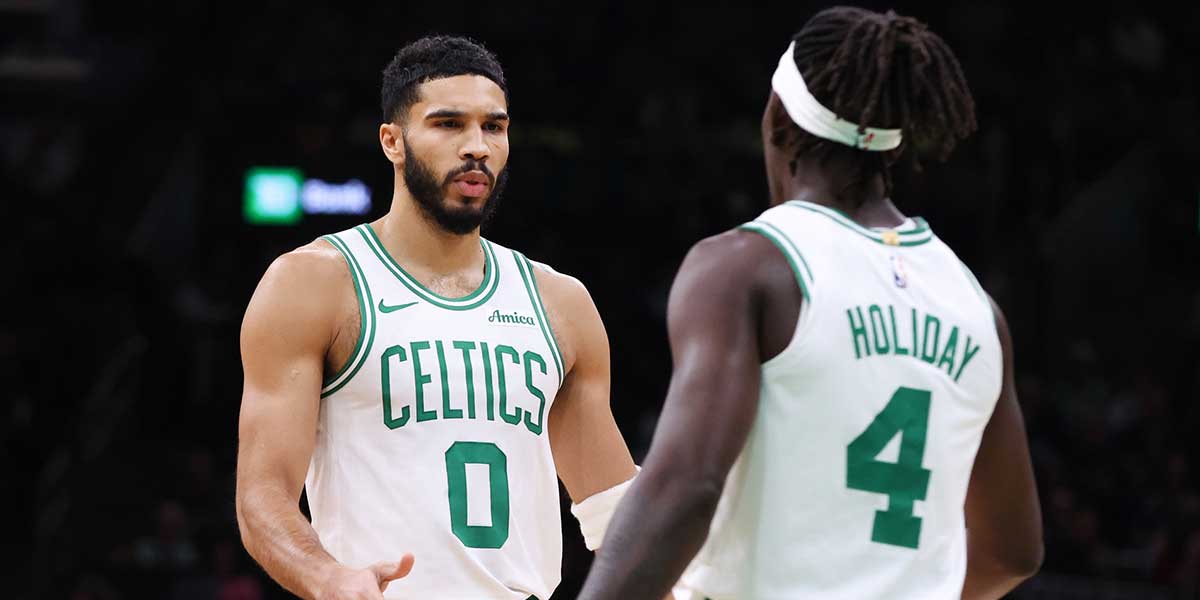Boston Celtics forward Jayson Tatum (0) celebrates with Boston Celtics guard Jrue Holiday (4) during the first half against the Memphis Grizzlies at TD Garden.