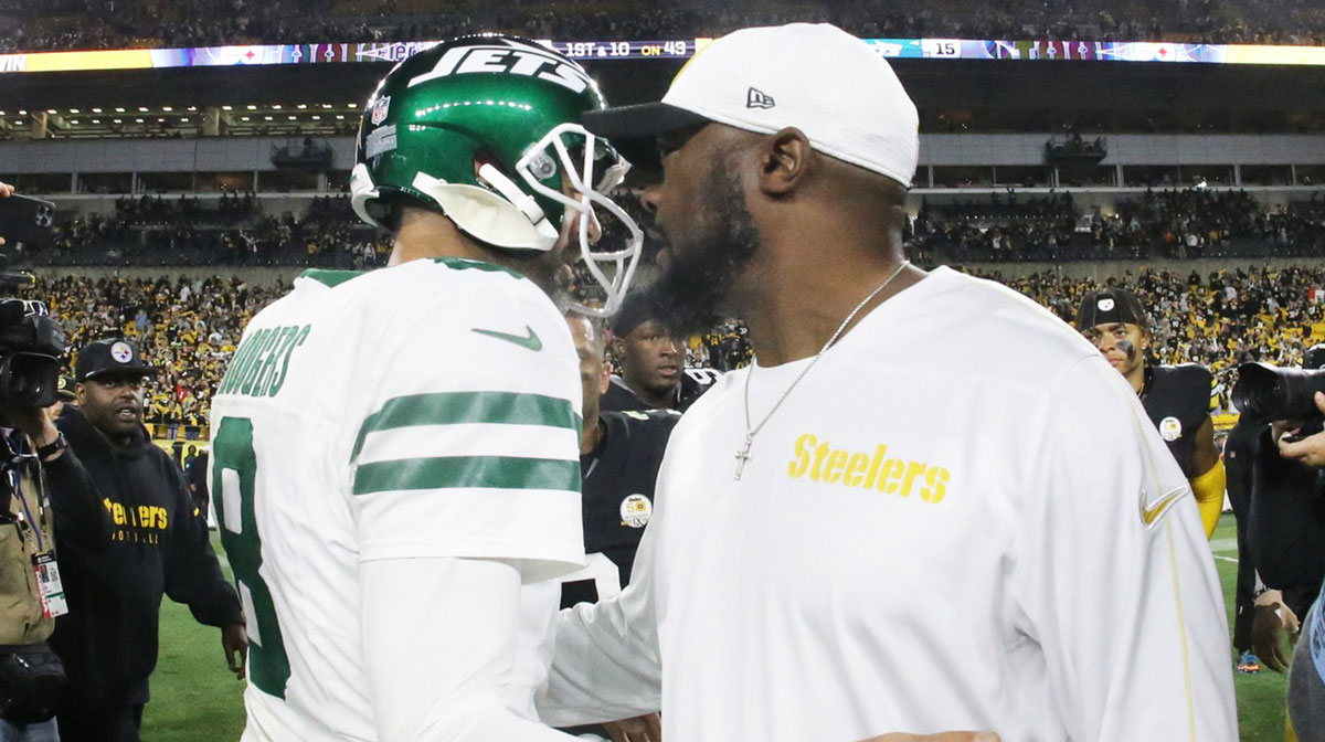 New York Jets quarterback Aaron Rodgers (8) and Pittsburgh Steelers head coach Mike Tomlin (right) greet each other after their game at Acrisure Stadium.
