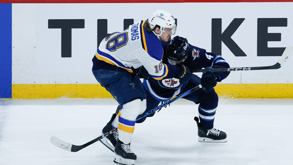 Winnipeg Jets defenseman Neal Pionk (4) steps into St. Louis Blues forward Robert Thomas (18) during the third period in game one of the first round of the 2025 Stanley Cup Playoffs at Canada Life Centre.