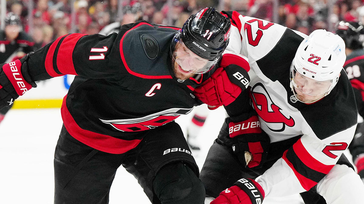 Carolina Hurricanes center Jordan Staal (11) chases after the puck against New Jersey Devils defenseman Brett Pesce (22) during the first period of game one of the first round of the 2025 Stanley Cup Playoffs at Lenovo Center.
