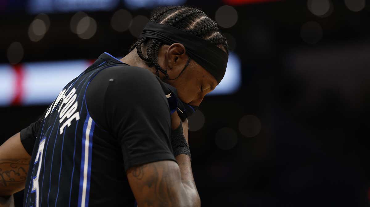 Orlando Magic guard Kentavious Caldwell-Pope (3) holds his face after an elbow by Washington Wizards guard Bub Carrington (8) in the second half at Capital One Arena.