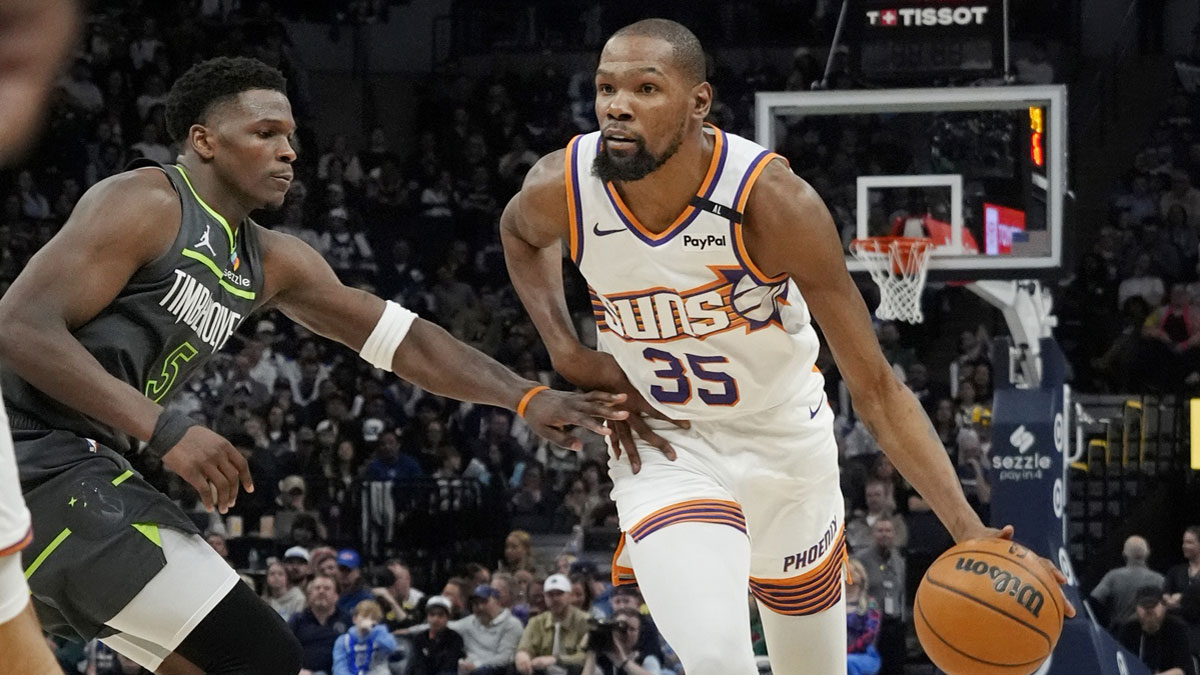 Phoenix Suns forward Kevin Durant (35) brings the ball up as Minnesota Timberwolves guard Anthony Edwards (5) defends him in the fourth quarter at Target Center.