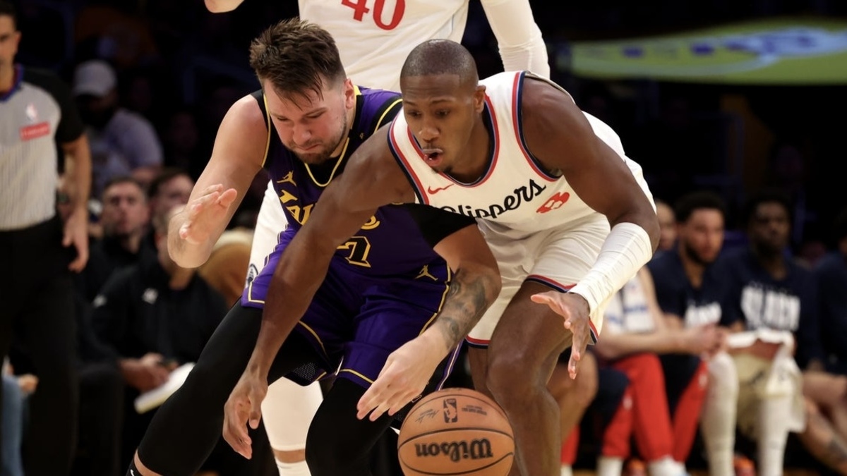 Los Angeles Lakers guard Luka Doncic (77) and LA Clippers guard Kris Dunn (8) chase a loose ball during the second quarter at Crypto.com Arena.