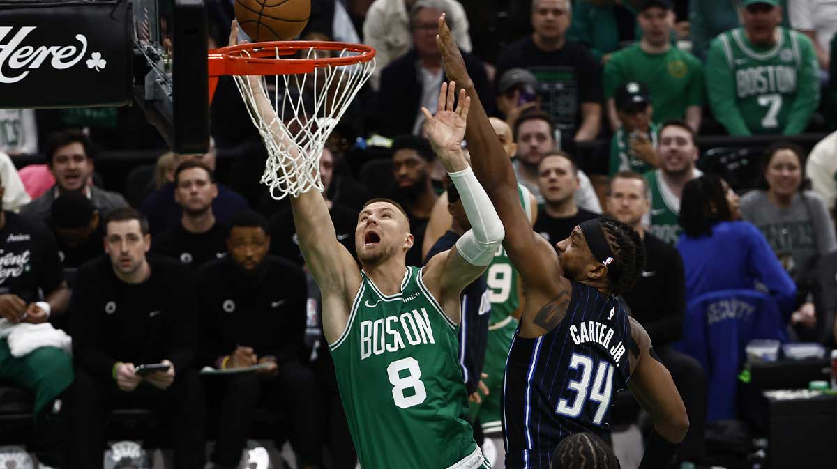 Boston Celtics center Kristaps Porzingis (8) goes to the basket past Orlando Magic center Wendell Carter Jr. (34) during the first quarter of game two of the first round of the 2024 NBA Playoffs at TD Garden.