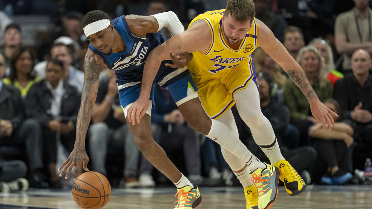 Minnesota Timberwolves forward Jaden McDaniels (3) and Los Angeles Lakers guard Luka Doncic (77) fight for the ball in the first half during game three of first round for the 2024 NBA Playoffs at Target Center.