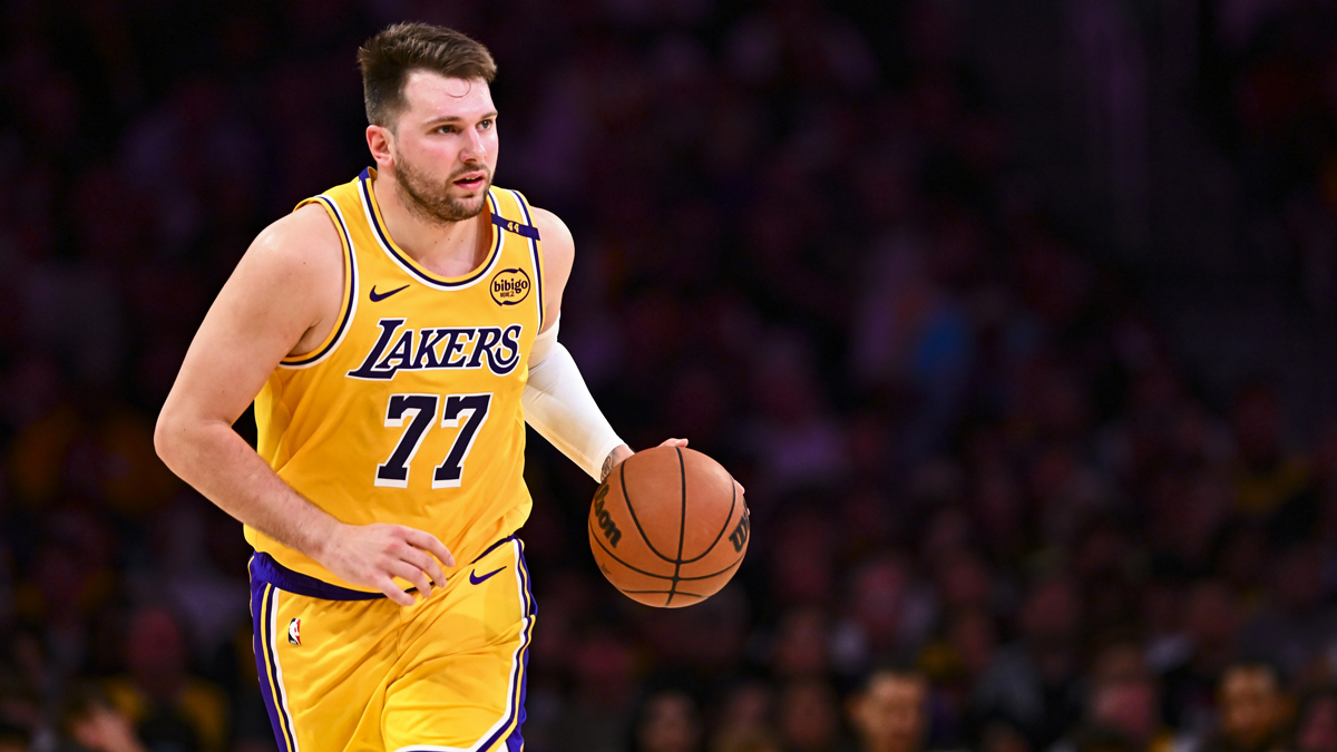 Lakers guard Luka Doncic (77) moves the ball against the Houston Rockets during the first half at Crypto.com Arena next to Jeanie Buss with Wayne Gretzky in the background