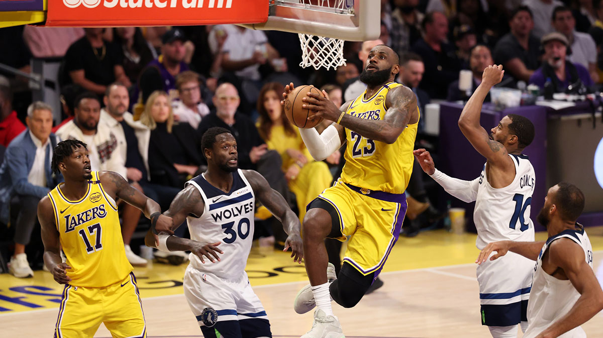 Los Angeles Lakers forward LeBron James (23) goes to the basket between Minnesota Timberwolves forward Julius Randle (30) and guard Mike Conley (10) during the fourth quarter of game two of first round for the 2024 NBA Playoffs at Crypto.com Arena.