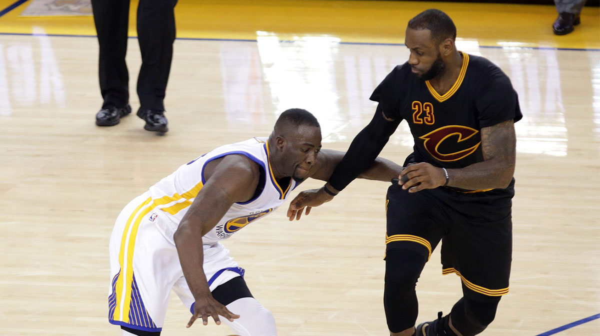 Golden State Warriors forward Draymond Green (23) moves the ball against Cleveland Cavaliers forward LeBron James (23) in the second half in game seven of the NBA Finals at Oracle Arena.