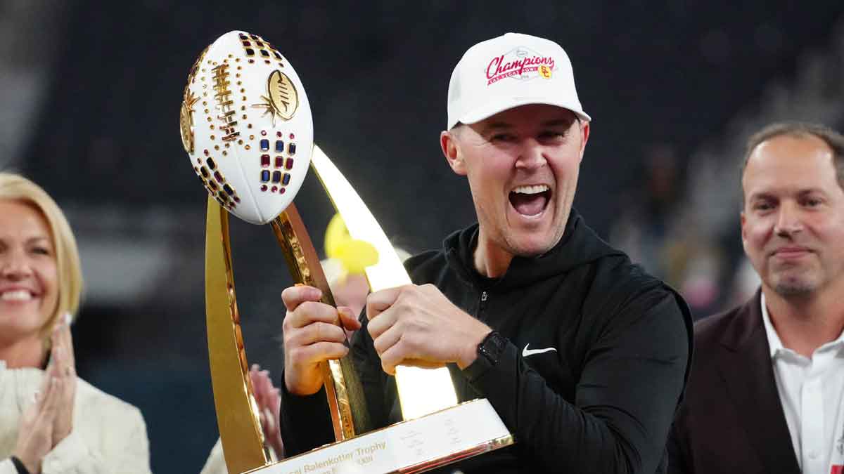 Southern California Trojans head coach Lincoln Riley holds the championship trophy after the game against the Texas A&M Aggies at Allegiant Stadium.