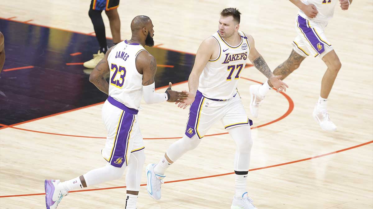 Los Angeles Lakers guard Luka Doncic (77) and forward LeBron James (23) high five after scoring against the Oklahoma City Thunder during the first quarter at Paycom Center.