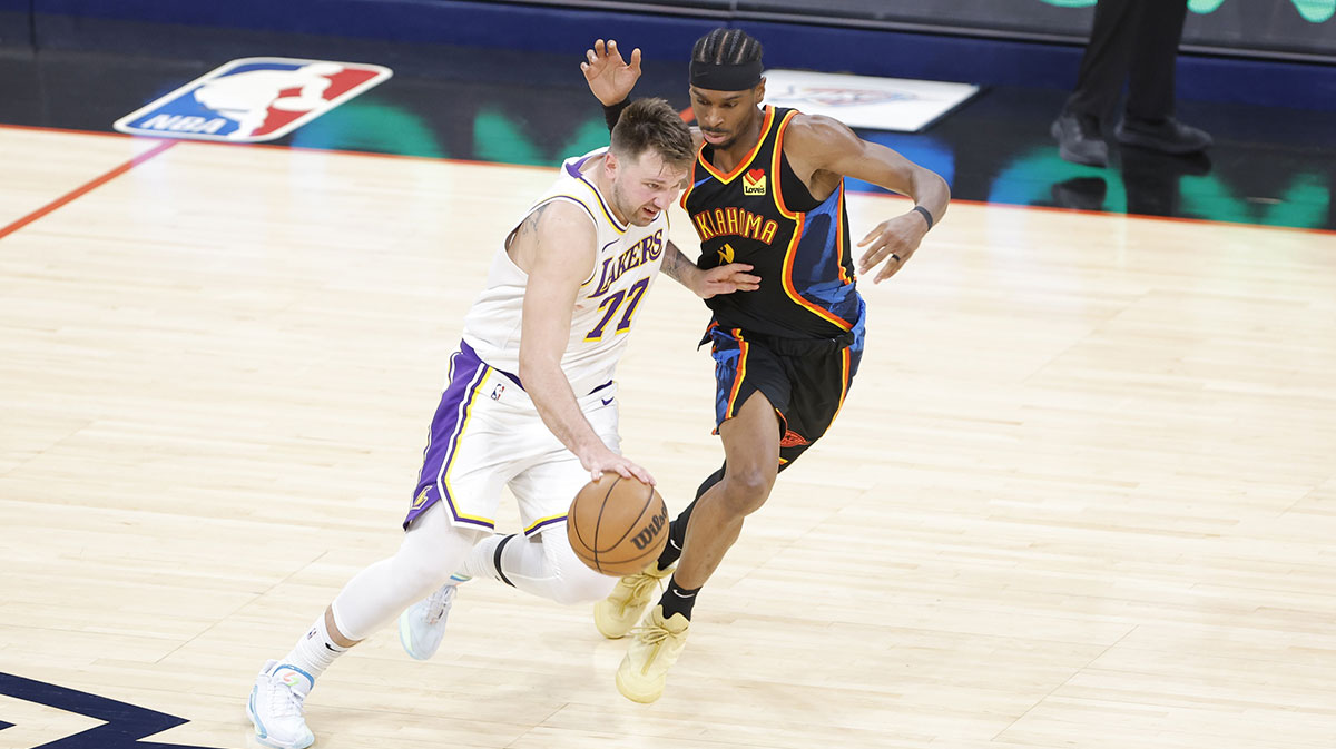Los Angeles Lakers guard Luka Doncic (77) drives down the court beside Oklahoma City Thunder guard Shai Gilgeous-Alexander (2) during the second half at Paycom Center.