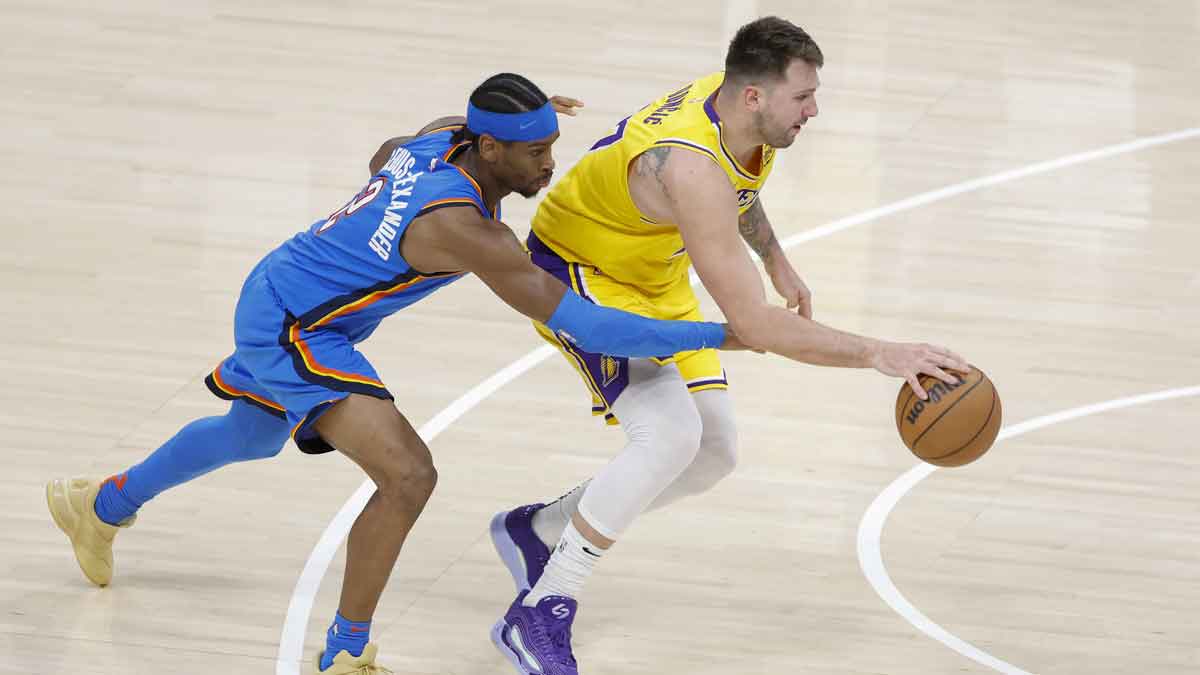 Oklahoma City Thunder guard Shai Gilgeous-Alexander (2) reaches to steal the ball from Los Angeles Lakers guard Luka Doncic (77) during the second half at Paycom Center.