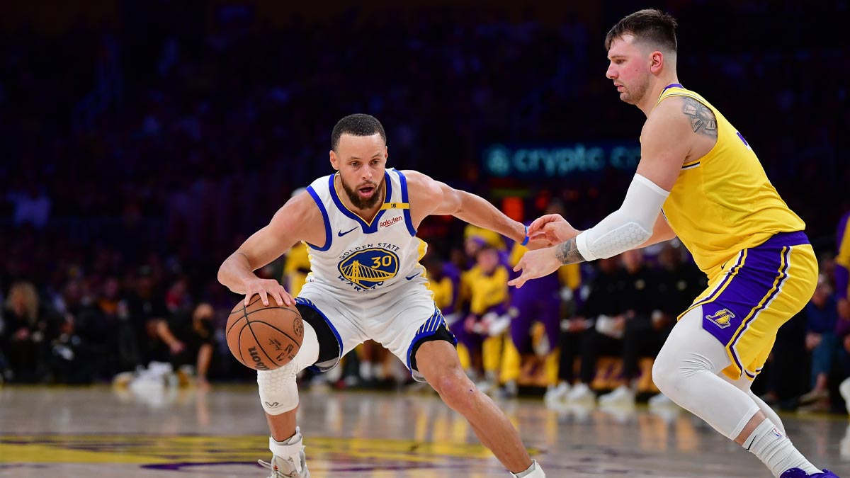 Los Angeles, California, USA; Golden State Warriors guard Stephen Curry (30) controls the ball against Los Angeles Lakers guard Luka Doncic (77) during the second half at Crypto.com Arena.