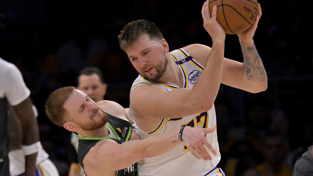 Minnesota Timberwolves guard Donte DiVincenzo (0) reaches in on Los Angeles Lakers guard Luka Doncic (77) in the second half at Crypto.com Arena.