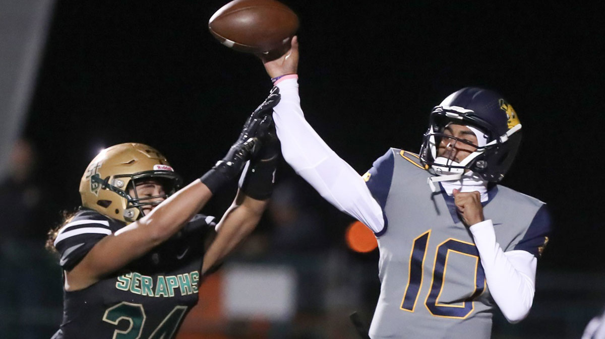 Warren quarterback Madden Iamaleava is under pressure by St. Bonaventure's Jacob Moraga as he fires a pass during the first quarter of the Seraphs' 24-21 win in the CIF-SS Division 3 championship game on Saturday, Nov. 25, 2023, at Ventura High's Larrabee Stadium.