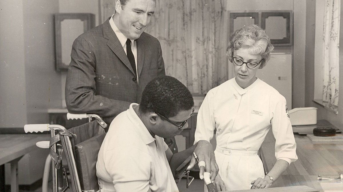 Former Royal Maurice Stokes undergoes physical therapy exercises at Good Samaritan Hospital under the watchful eye of former teammate Jack Twyman and occupational therapist Mary Jo Ellis.
