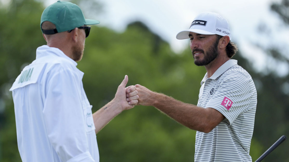 Max Homa fist bumps his caddie, Bill Harke, after finishing his round on the no. 18 green during the second round of the Masters Tournament at Augusta National Golf Club.