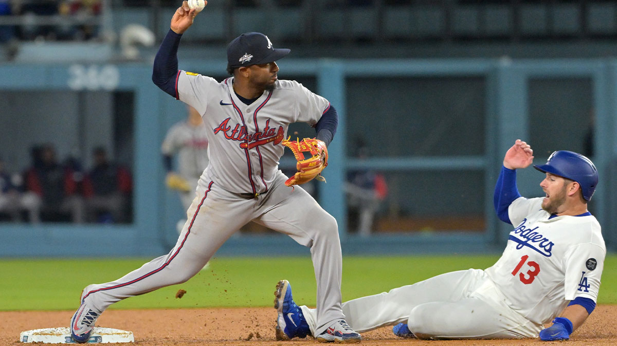 Atlanta Braves second baseman Ozzie Albies (1) turns a double play over Los Angeles Dodgers third baseman Max Muncy (13) during the second inning at Dodger Stadium. Mandatory Credit: Jayne Kamin-Oncea-Imagn Images