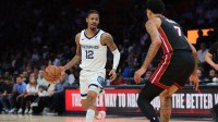Memphis Grizzlies guard Ja Morant (12) dribbles the basketball as Miami Heat center Kel'el Ware (7) defends during the first quarter at Kaseya Center.