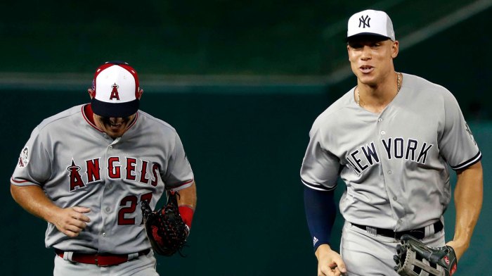 American League outfielder Aaron Judge of the New York Yankees (99) and American League outfielder Mike Trout of the Los Angeles Angels (27) run to the dug out after the first inning in the 2018 MLB All Star Game at Nationals Ballpark.