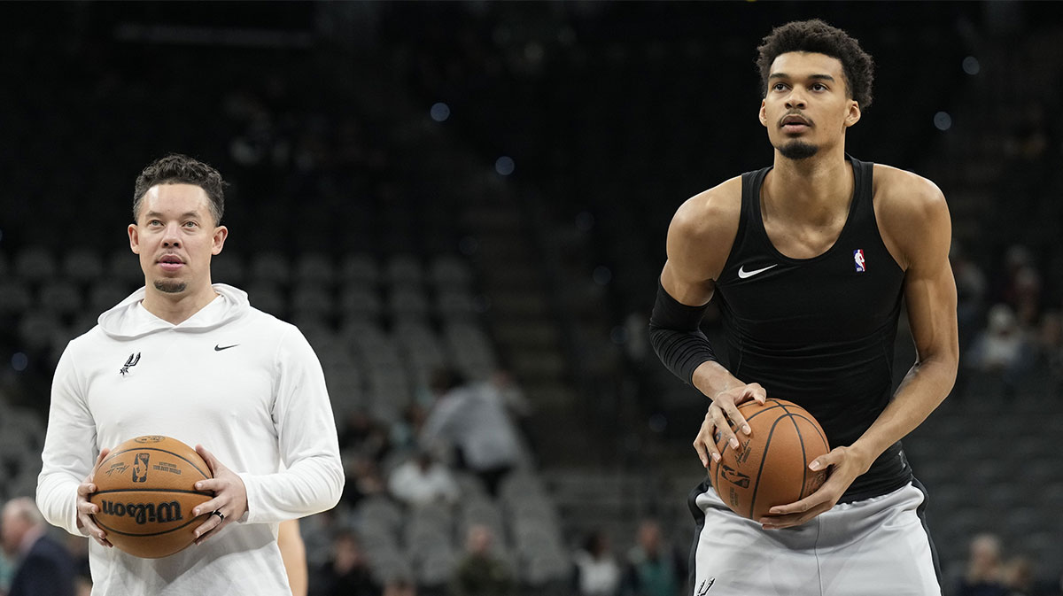 San Antonio Spurs interim coach Mitch Johnson looks on as center Victor Wembanyama (1) shoots free throws before a game against the Memphis Grizzlies at Frost Bank Center.