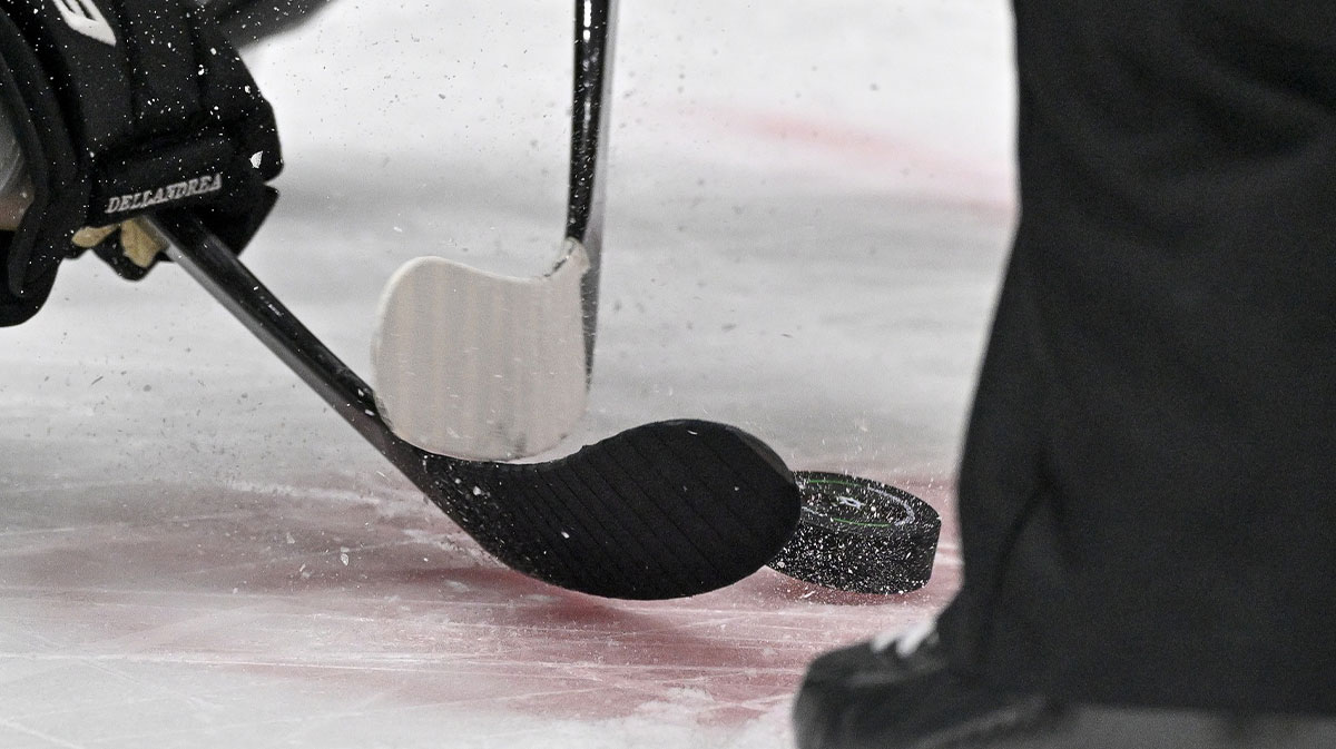 A view of the face-off circle and an NHL puck and the Dallas Stars logo and hockey sticks during a face-off in the third period of the game between the Dallas Stars and the New York Islanders at the American Airlines Center.
