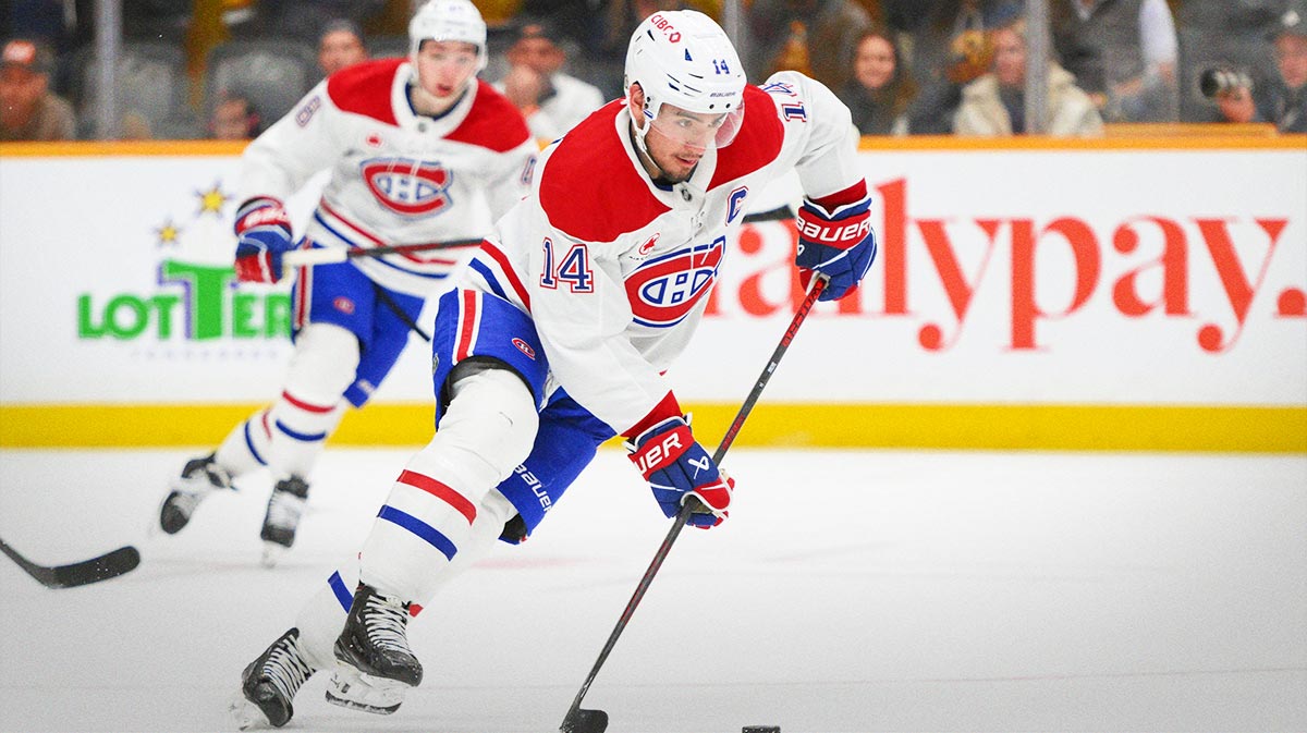 Montreal Canadiens center Nick Suzuki (14) clears the puck from his zone against the Nashville Predators during the second period at Bridgestone Arena.