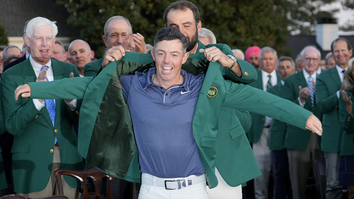 Scottie Scheffler presents Rory McIlroy with the green jacket after winning the Masters Tournament at Augusta National Golf Club.