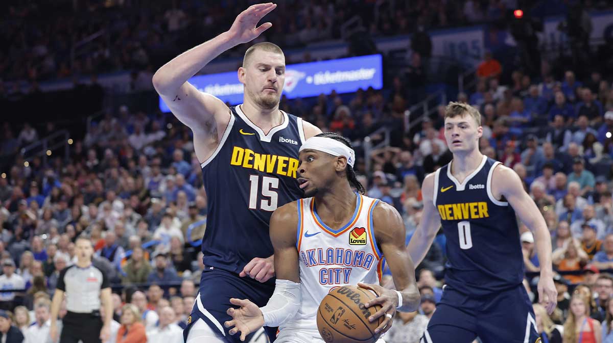Denver Nuggets center Nikola Jokic (15) defends a drive by Oklahoma City Thunder guard Shai Gilgeous-Alexander (2) during the second half at Paycom Center.