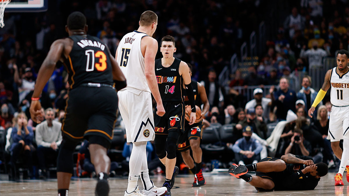 Miami Heat forward Markieff Morris (8) lies on the ground after a play with Denver Nuggets center Nikola Jokic (15) as guard Tyler Herro (14) and center Bam Adebayo (13) react in the fourth quarter at Ball Arena.