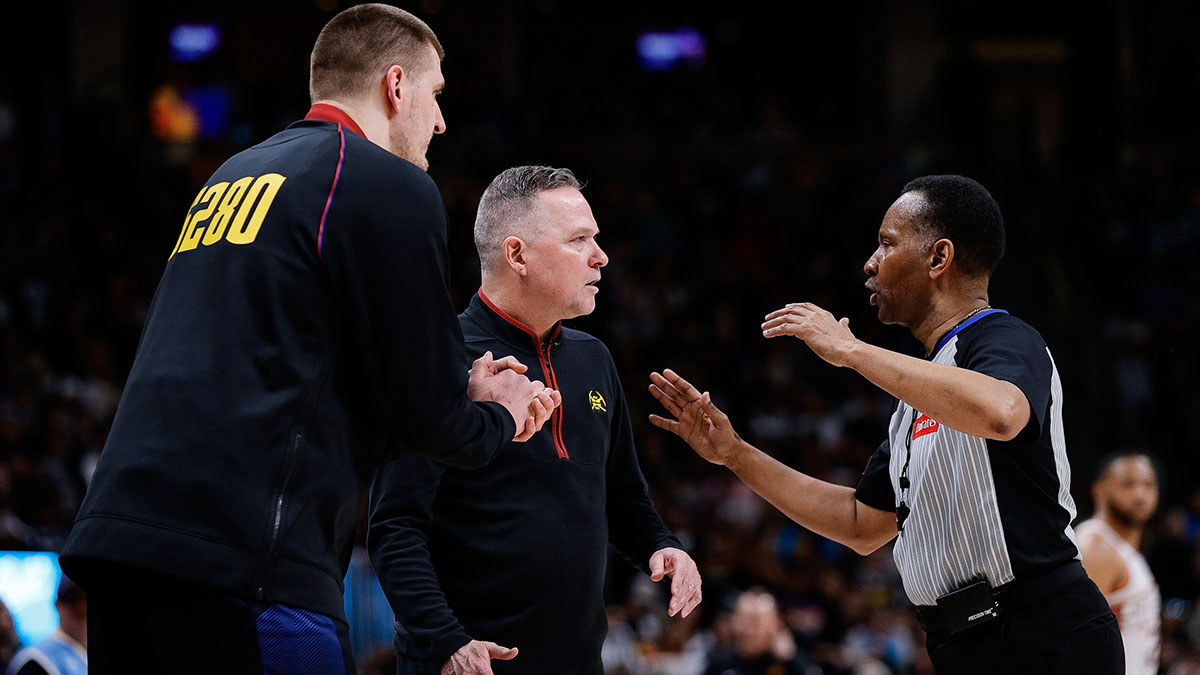 Denver Nuggets center Nikola Jokic (L) and head coach Michael Malone (C) argue a call with referee James Capers (R) in the second quarter against the Phoenix Suns at Ball Arena.