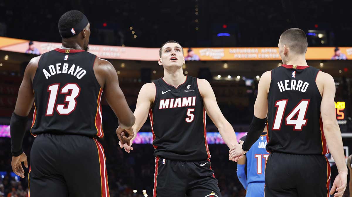 Miami Heat forward Nikola Jovic (5) celebrates with teammates center Bam Adebayo (13) and guard Tyler Herro (14) after a play against the Oklahoma City Thunder during the second quarter at Paycom Center.