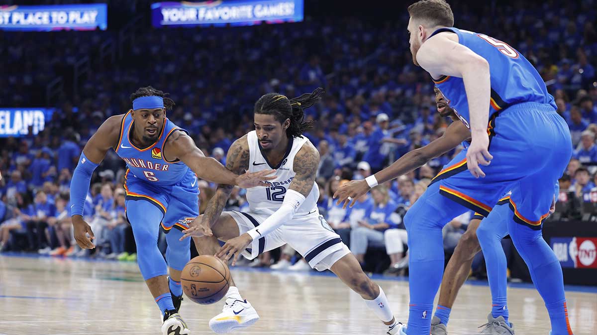 Memphis Grizzlies guard Ja Morant (12) and Oklahoma City Thunder guard Luguentz Dort (5) reach for a loose ball in the third quarter during game two of first round for the 2024 NBA Playoffs at Paycom Center.