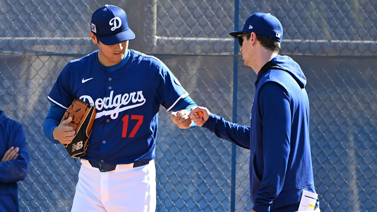 Los Angeles Dodgers designated hitter Shohei Ohtani (17) fist pumps with Los Angeles Dodgers assistant pitching coach Connor McGuiness (87) during a spring training bullpen session at Camelback Ranch.