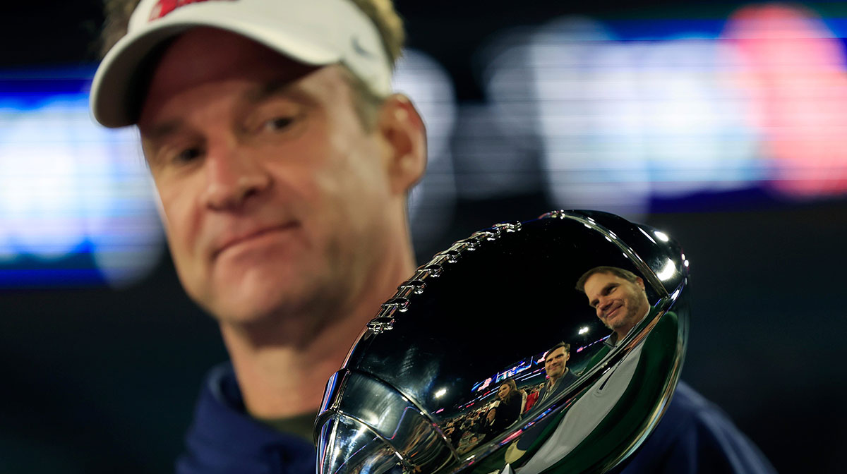 Mississippi Rebels head coach Lane Kiffin looks at the Ash Verlander Champions Trophy after the game of the TaxSlayer Gator Bowl Thursday, Jan. 2, 2025 at EverBank Stadium in Jacksonville, Fla. Ole Miss defeated Duke 52-20