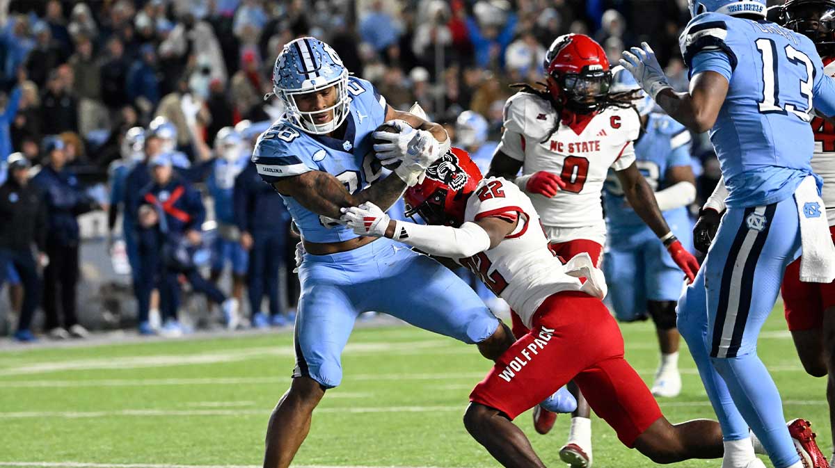 North Carolina Tar Heels running back Omarion Hampton (28) scores a touchdown as North Carolina State Wolfpack cornerback Jackson Vick (22) defends in the fourth quarter at Kenan Memorial Stadium. Mandatory Credit: Bob Donnan-Imagn Images