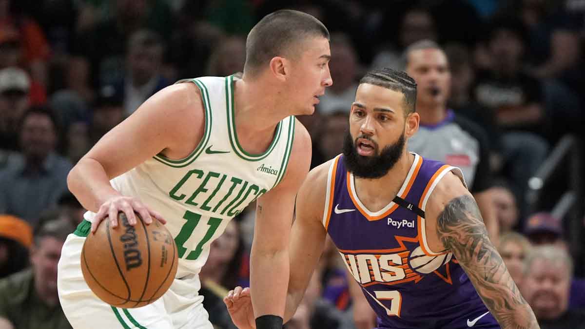 Boston Celtics guard Payton Pritchard (11) drives on Phoenix Suns forward Cody Martin (17) during the first half at Footprint Center.