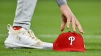Philadelphia Phillies third baseman Alec Bohm (28) picks up his hat after chasing down a fly ball against the St. Louis Cardinals during the third inning at Busch Stadium.