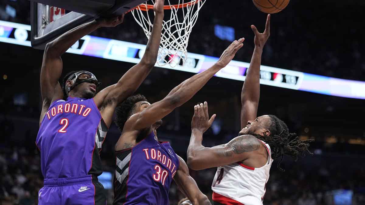 Portland Trail Blazers forward Jabari Walker (34) goes up to make a basket as Toronto Raptors forward Jonathan Mogbo (2) and forward Ochai Agbaji (30) defend during the second half at Scotiabank Arena.
