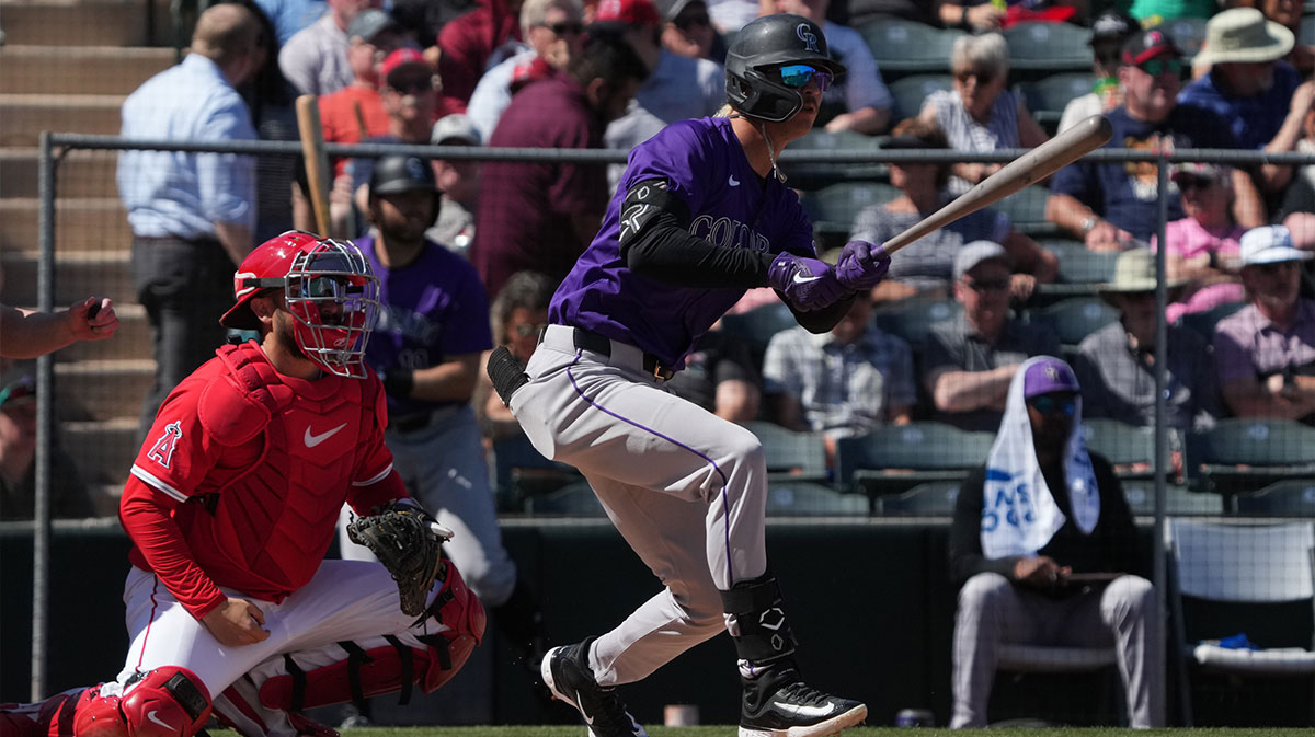 Colorado Rockies outfielder Zac Veen (13) hits a single against the Los Angeles Angels in the second inning at Tempe Diablo Stadium.