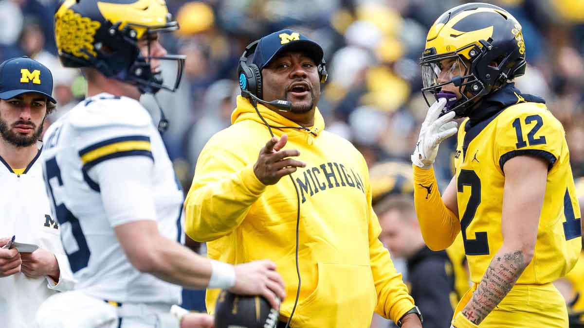 Michigan offensive pass game coordinator and wide receivers coach Ron Bellamy talks to quarterback Davis Warren (16) during the second half of the spring game at Michigan Stadium
