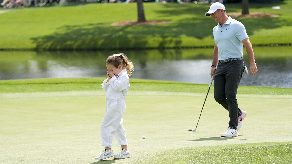 Rory McIlroy’s daughter, Poppy, hides her face as she laughs during the Par 3 Contest at Augusta National Golf Club