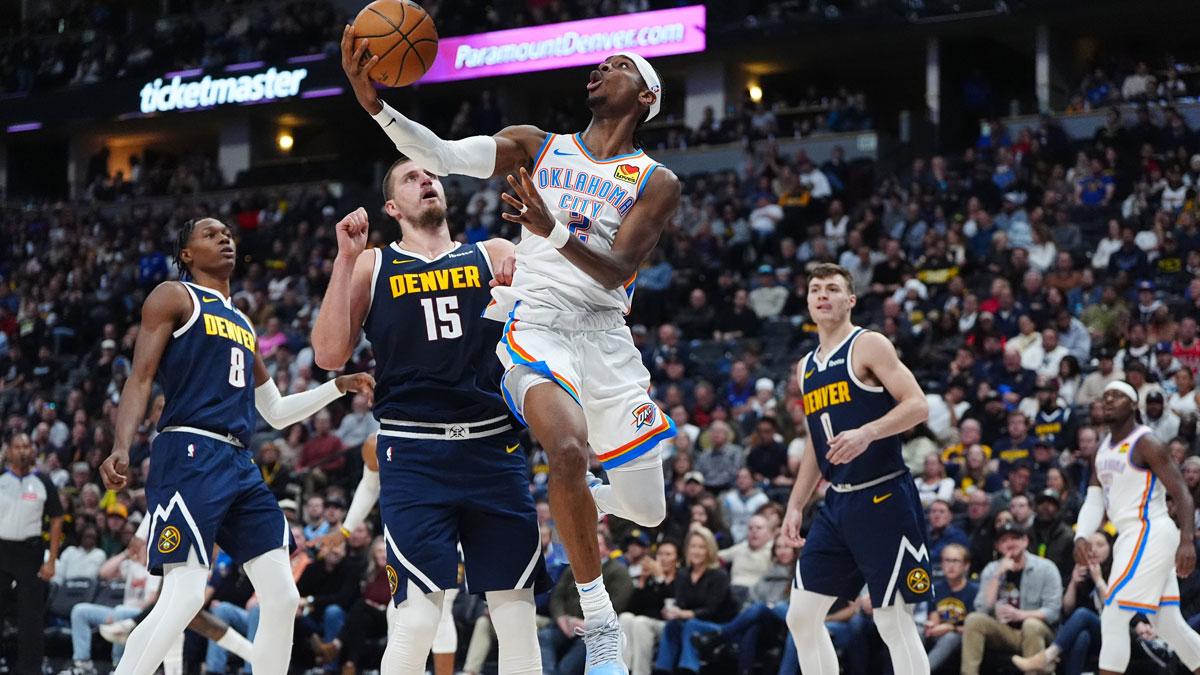 Oklahoma City Thunder guard Shai Gilgeous-Alexander (2) shoots the ball past Denver Nuggets center Nikola Jokic (15) in the second quarter at Ball Arena.