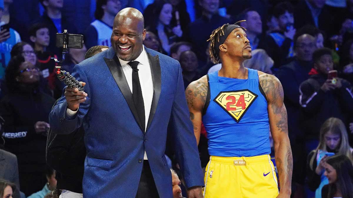 Former NBA player Shaquille O'Neal laughs while standing next to Los Angeles Lakers player Dwight Howard during the slam dunk contest during NBA All Star Saturday Night at United Center.