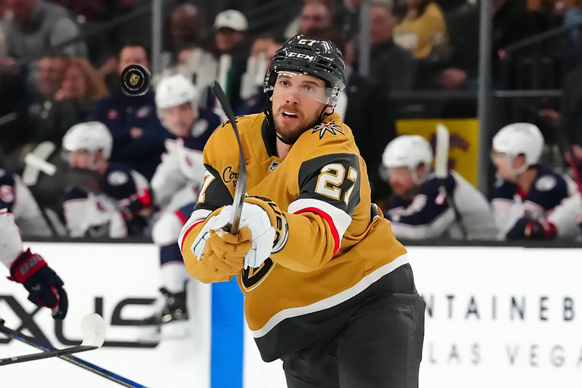 Vegas Golden Knights defenseman Shea Theodore (27) looks to control a dump in by the Columbus Blue Jackets during the first period at T-Mobile Arena.