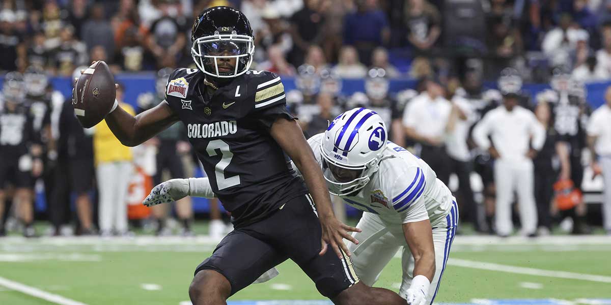 Dec 28, 2024; San Antonio, TX, USA; Colorado Buffaloes quarterback Shedeur Sanders (2) attempts to avoid a tackle by Brigham Young Cougars safety Raider Damuni (3) during the second quarter at Alamodome.